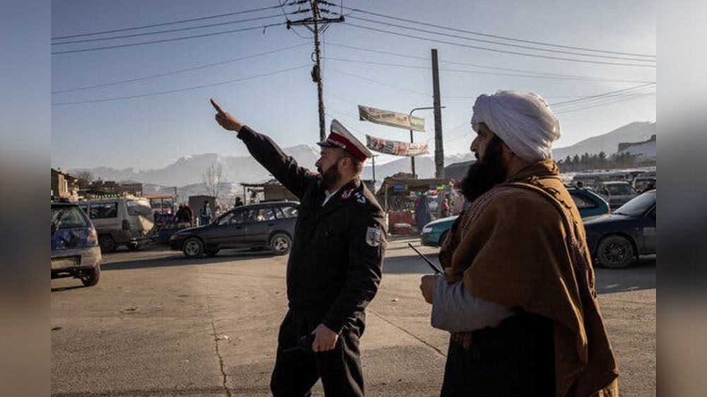 آقای غیور (سمت راست) در حال بازدید از مأموران پولیس ترافیک در کابل. اعتبار عکس جیم هویلبروک برای نیویورک تایمز